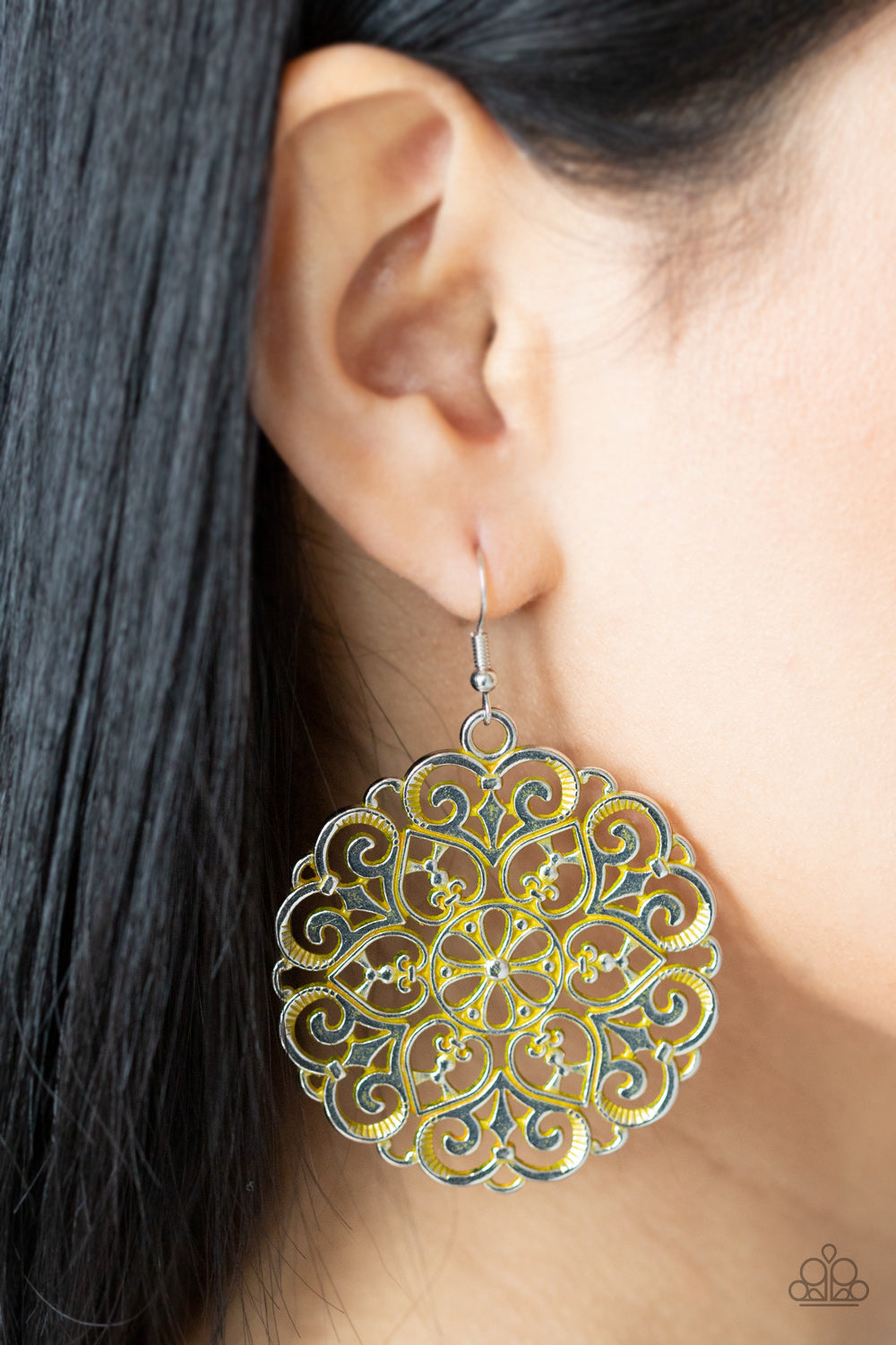 ustic yellow finish, an oversized mandala-like silver frame
