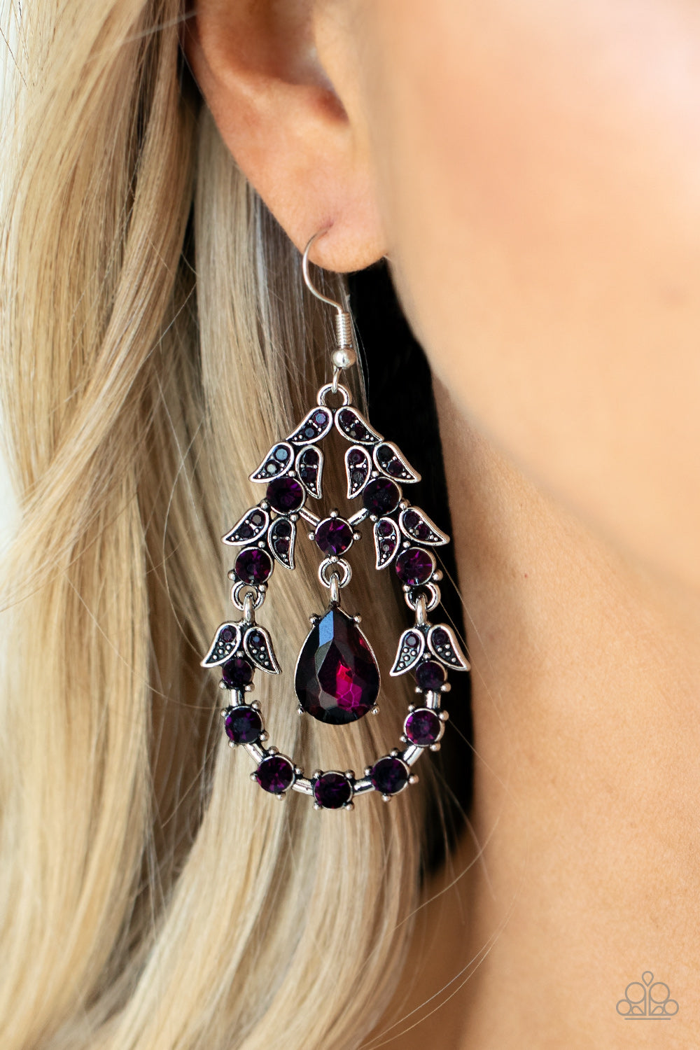 solitaire purple teardrop rhinestone swings from the top of an ornately hinged teardrop frame adorned in purple rhinestone dotted leafy silver frames