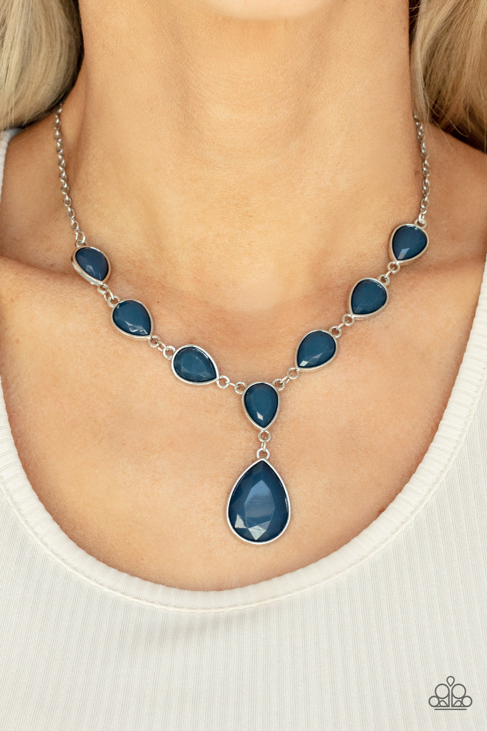 Encased in sleek silver fittings, a chain of faceted blue teardrops gives way to an oversized blue teardrop pendant for an enchanting pop of color 