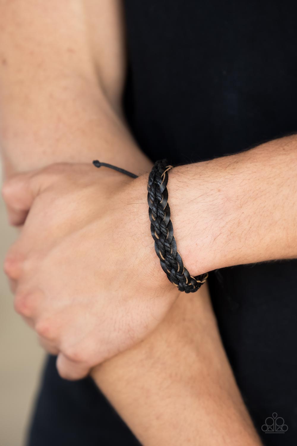 Black cording is woven through the center of braided black leather creating a trendy style around the wrist.