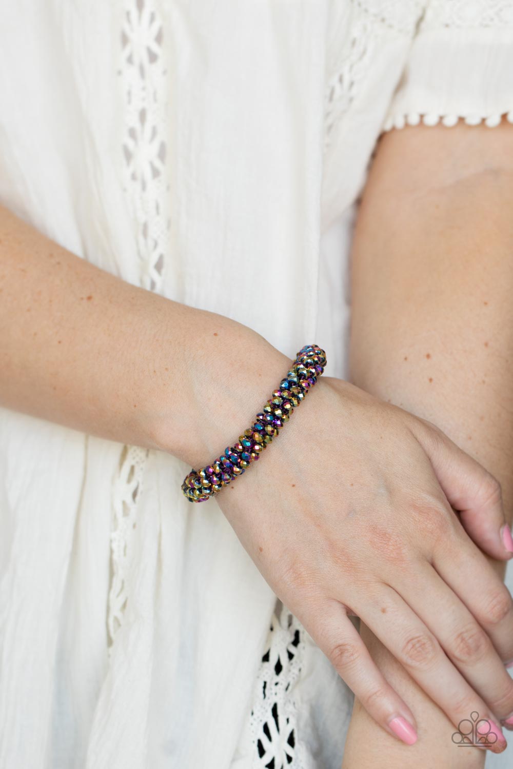 faceted dainty oil spill beads are threaded along a woven stretchy band