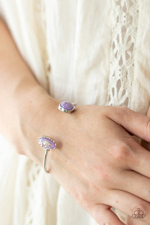 iridescent shell-like pieces are encased inside two mismatched glassy purple beads 