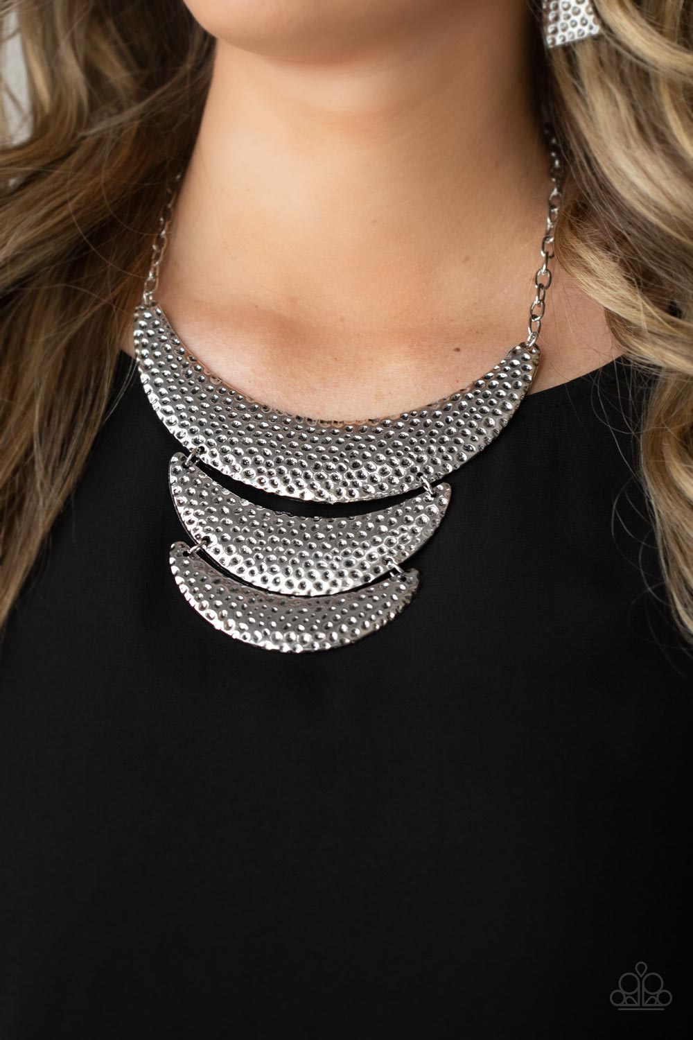 Hammered in an antiqued silver dimpled texture, a trio of crescent shaped plates in graduating sizes 