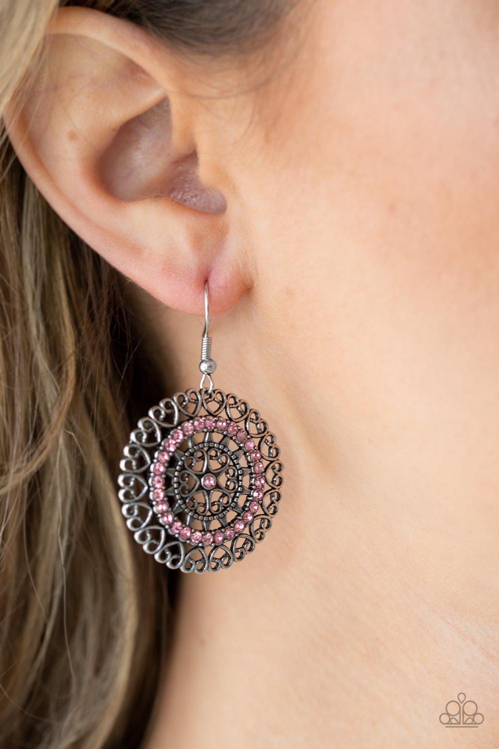 Silver heart shaped filigree frames spin into an enchanting display. Infused with a ring of glassy pink rhinestones