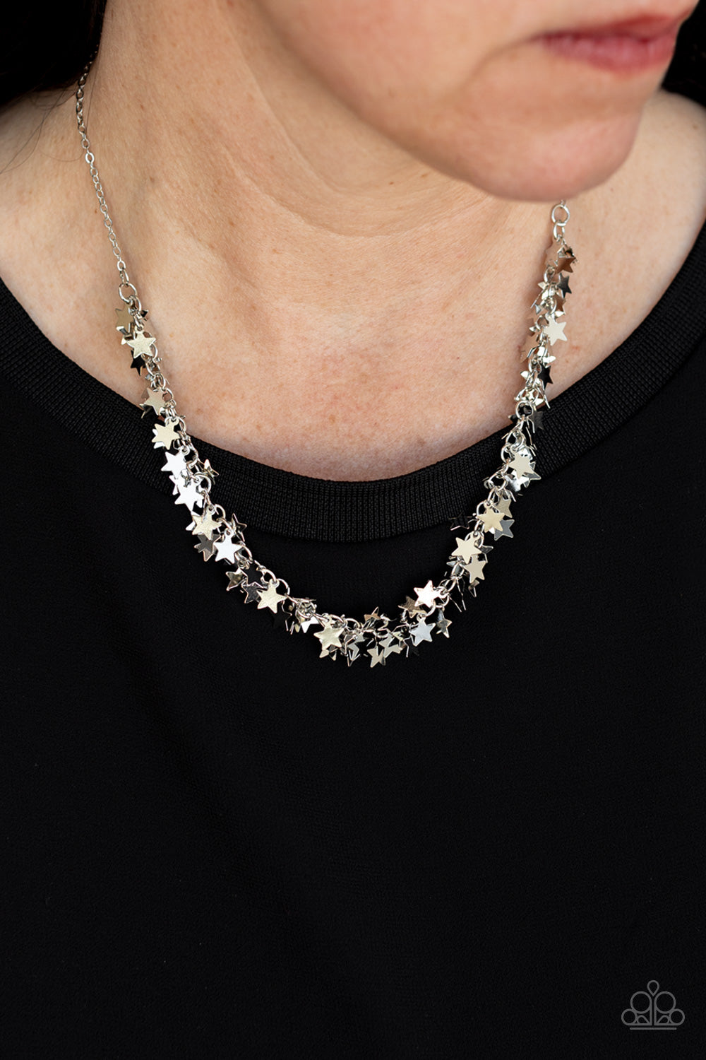 A glistening collection of dainty silver star charms delicately cluster on a classic silver chain