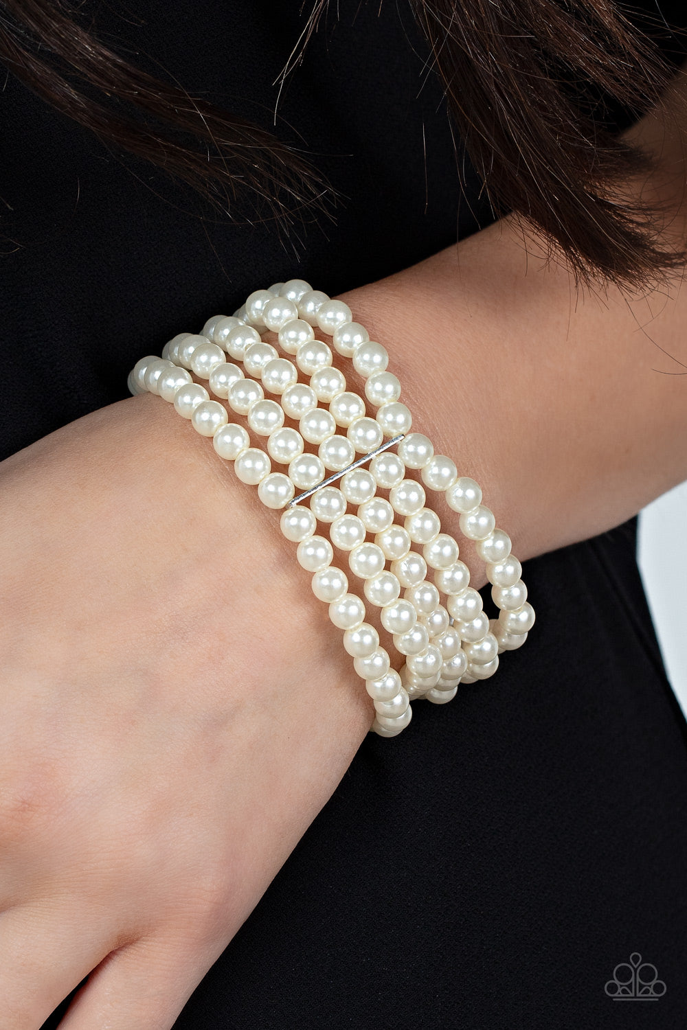 Stacked layers of luminous white pearl-like beads are threaded along stretchy bands