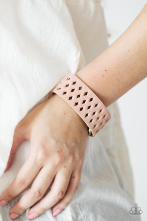  wide pink leather band is filled with patterned rows of small diamond-shaped cutouts giving the illusion of larger diamonds floating across the wrist 