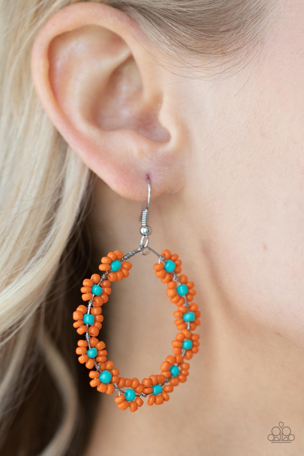 Dotted with turquoise beaded centers, a dainty collection of orange seed beaded floral frames are threaded along a wire hoop