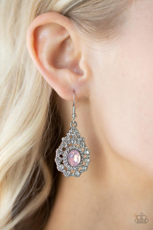 Bordered in a ring of dainty white rhinestones, an opalescent pink gem adorns the center of a teardrop frame radiating with glassy white rhinestones 