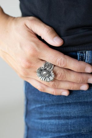 Brushed in an antiqued finish, a rustic silver daisy blooms atop a decorative studded and embossed silver band