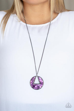 An airy hematite encrusted triangular frame is pressed into a gunmetal ring adorned in a purple shell-like frame. The colorful pendant swings from the bottom of a classic gunmetal chain