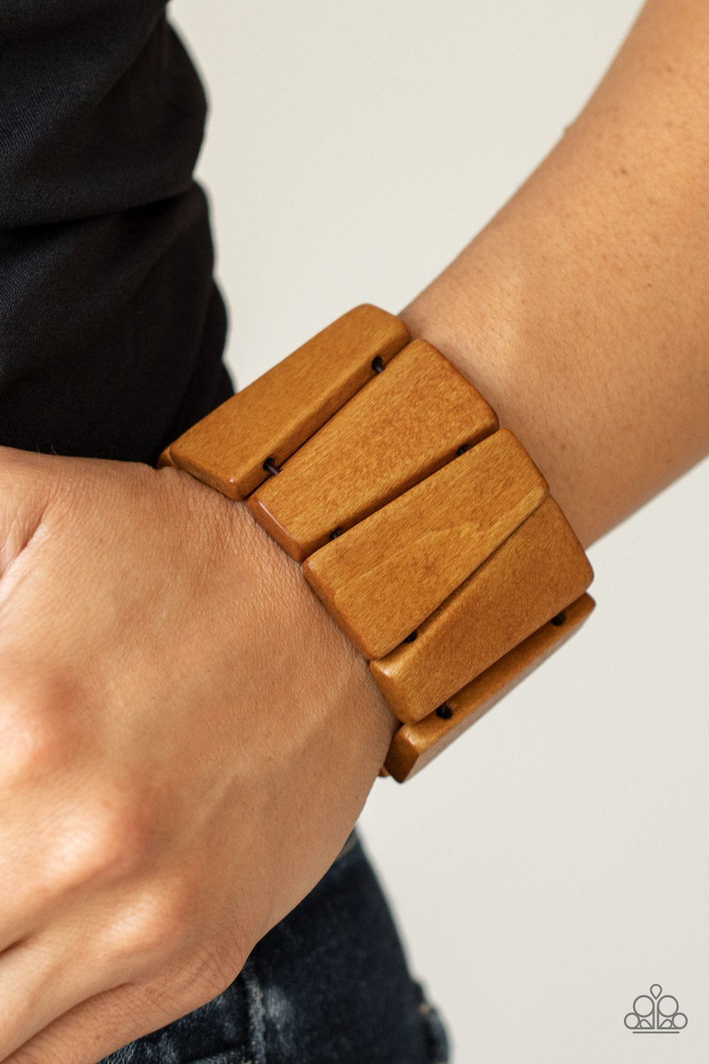 natural brown finish, chunky triangular wooden frames are threaded along stretchy bands around the wrist