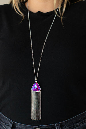 a UV shimmer, an oversized pink triangular gem swings from the bottom of a lengthened silver chain. A curtain of silver chains streams out from the bottom of the sparkly pendant
