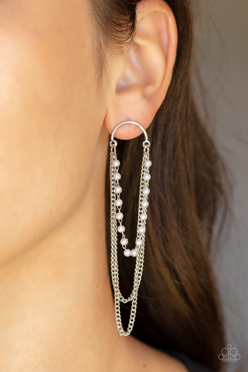 dainty white pearls and shimmery silver chains cascade from the bottom of a silver half moon frame