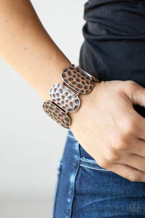 Rustically hammered copper oval frames and pairs of dainty copper beads are threaded along two stretchy bands