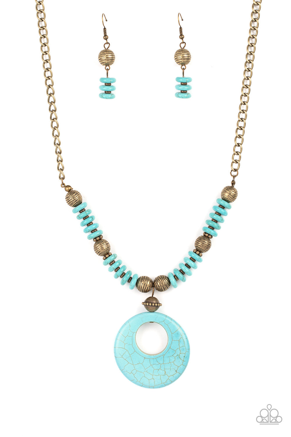 Infused with dainty brass accents, mismatched brass beads and turquoise stone discs are threaded along an invisible wire below the collar. An oversized turquoise stone pendant swings from the center of the earthy strand