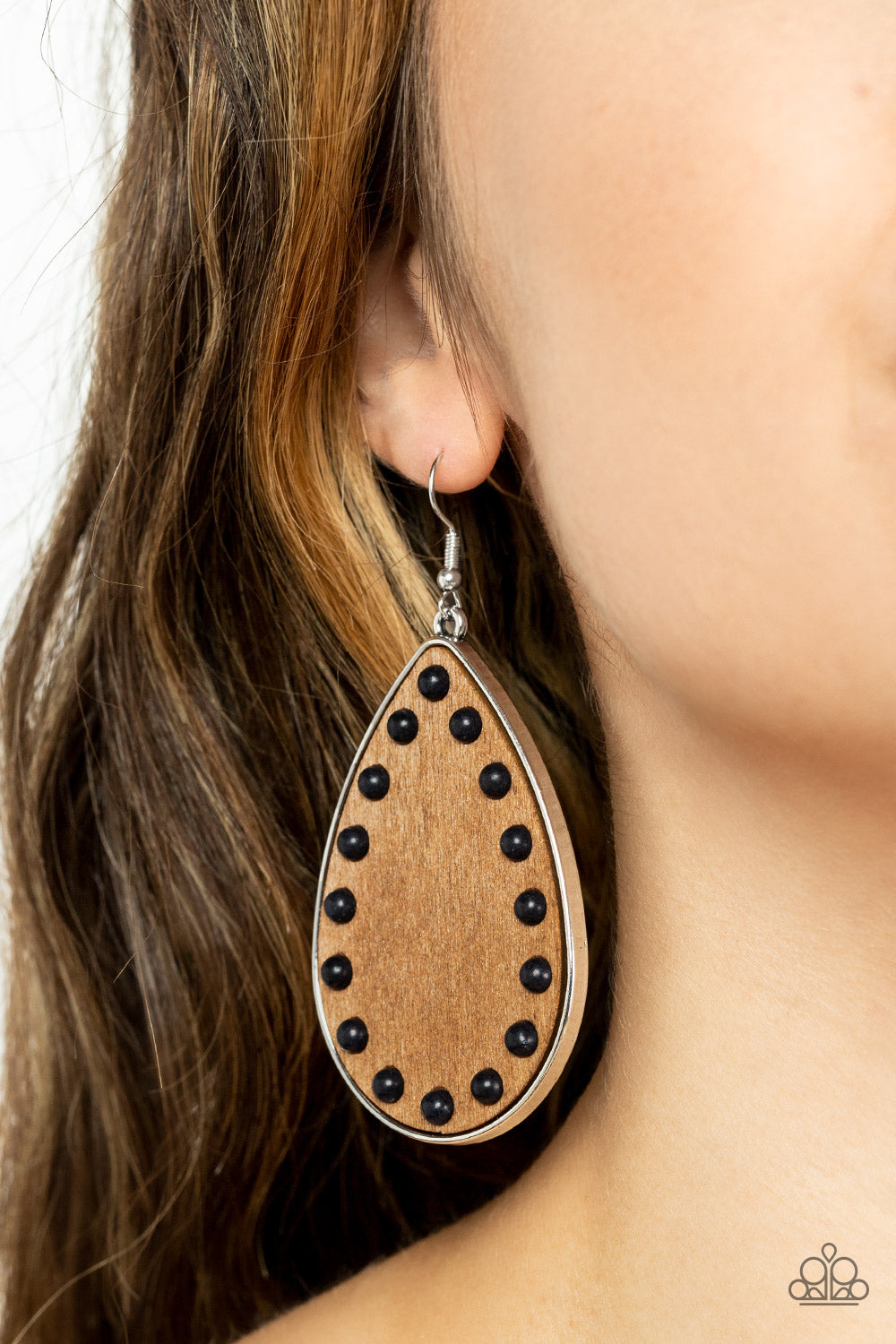 Dainty black stone beads border an earthy wooden teardrop frame that is encased in a sleek silver fitting, creating a whimsical woodsy lure. Earring attaches to a standard fishhook fitting.