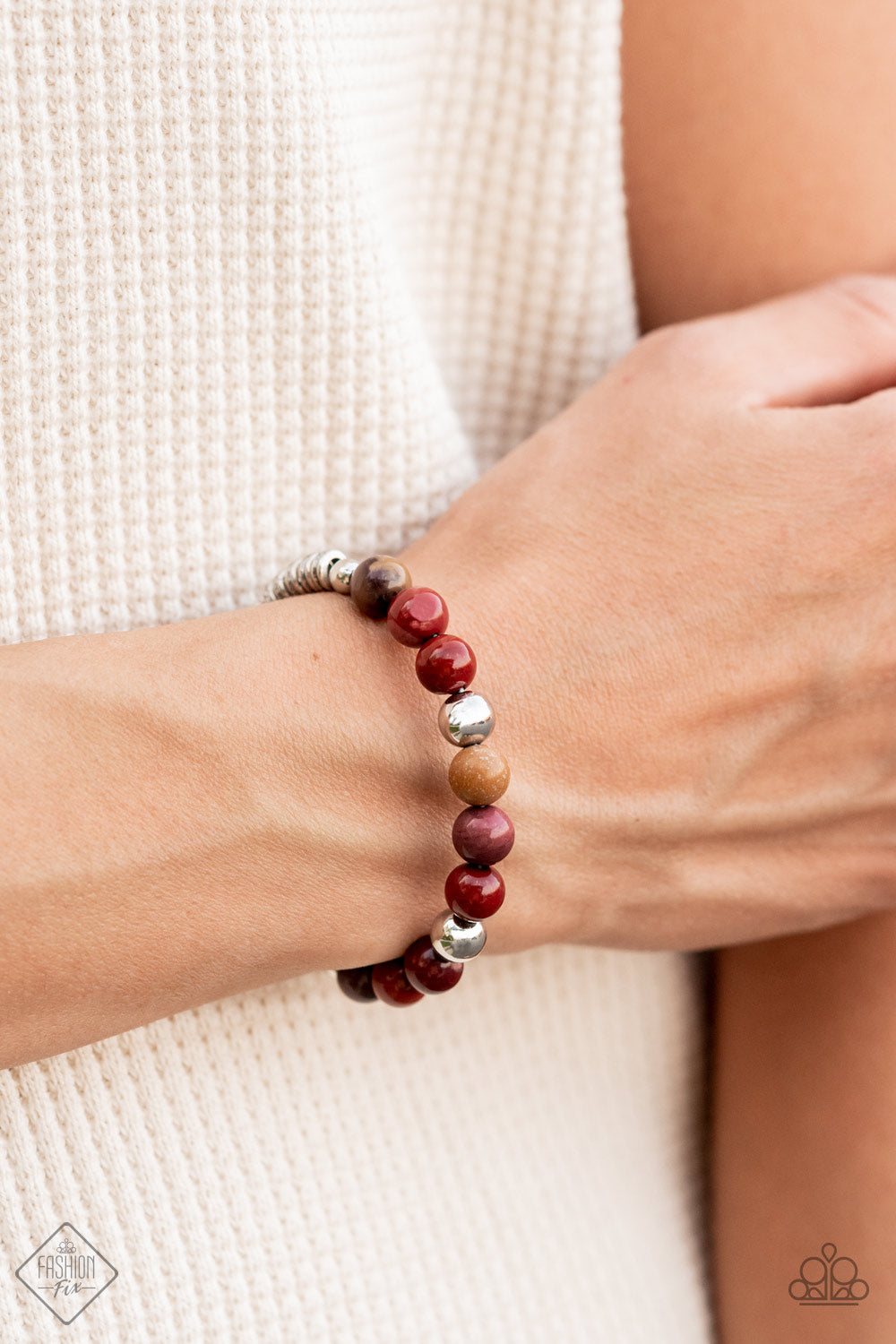 Accented with shiny silver beads, a collection of polished multicolored stone beads are fashioned into a wire cuff bracelet