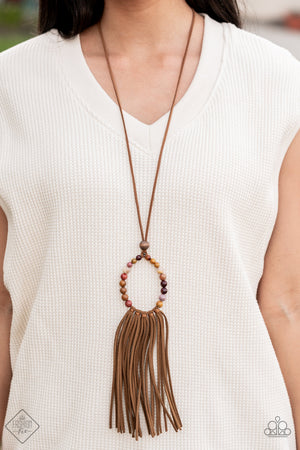 multicolored stone beads are threaded around a wire hoop that is fastened at the end of a lengthened brown suede cord