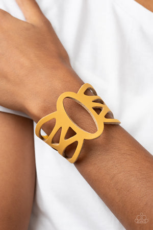 golden yellow leather band has been ornately cut into an airy stenciled pattern