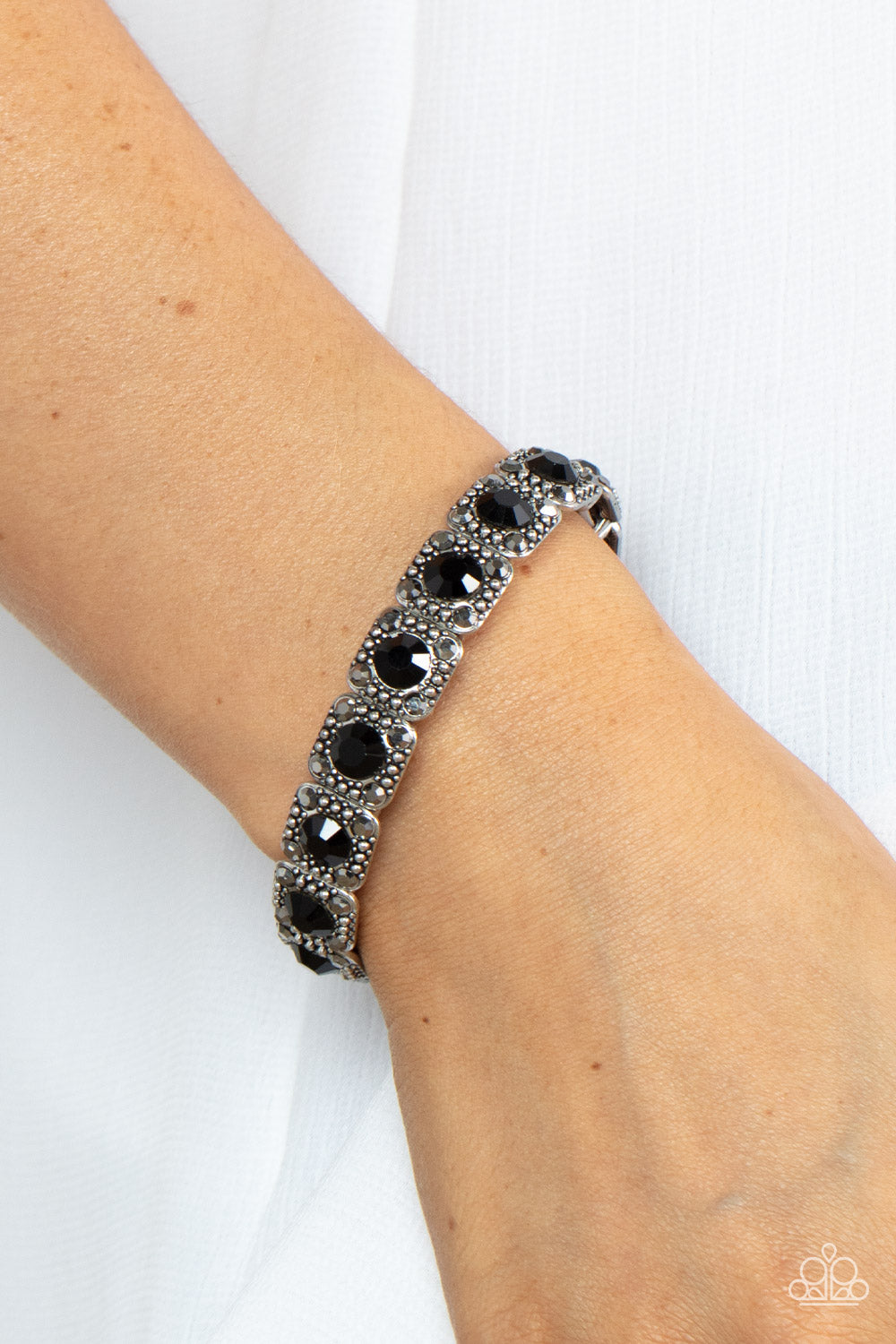 Dotted with oversized black rhinestone centers, the corners of silver studded frames are adorned in dainty hematite rhinestones 