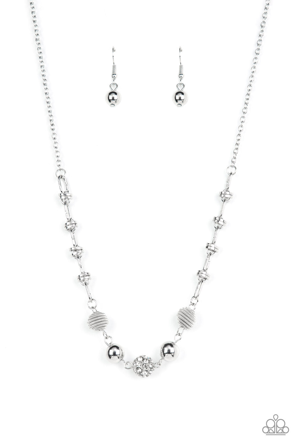 Pairs of silver coiled and smooth silver beads flank a white rhinestone encrusted bead along an oval and silver disc linked chain