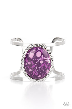 oversized purple stone is pressed into the center of a hammered silver frame