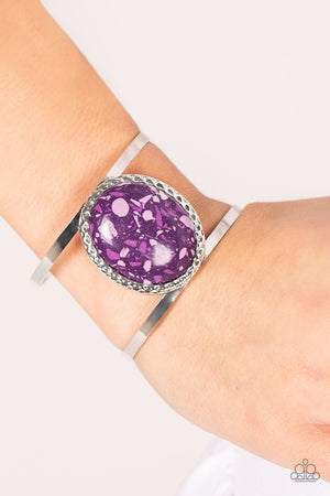 oversized purple stone is pressed into the center of a hammered silver frame