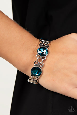 edgy chain-like fittings, a sparkly series of oversized blue rhinestones are threaded along stretchy bands