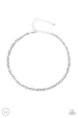 An ornately linked silver chain wraps around the neck, resulting in an edgy minimalist inspired grit