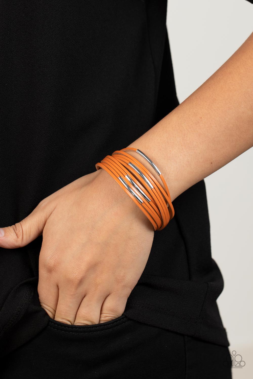 adorned with shiny silver frames, dainty orange leather bands layer around the wrist