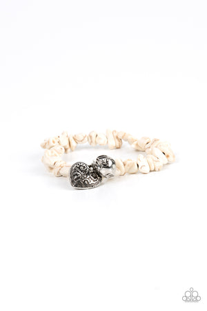 Infused with a hammered silver bead and decorative silver heart charm, an earthy collection of white pebbles are threaded along a stretchy band around the wrist