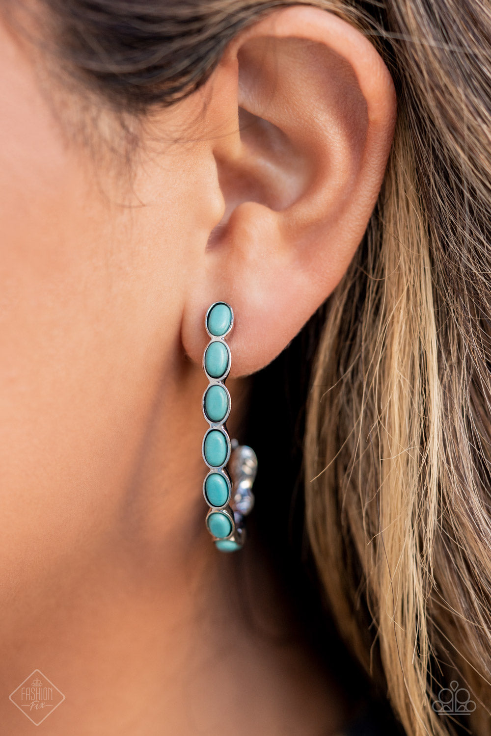 Small turquoise stones pressed into simple silver oval frames stack end to end as they fall from the ear and delicately curve into a J-shaped hoop