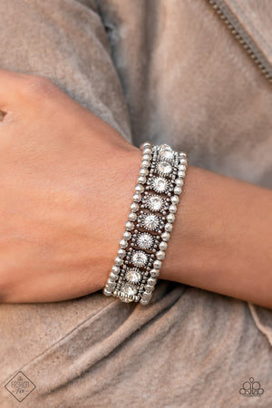 A dazzling row of sparkling white rhinestones set in dotted frames is bordered by a row of dainty antiqued silver studs