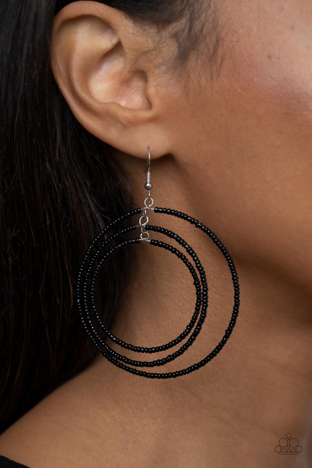 Three oversized rings of dainty black seed beads ripple into colorfully layered hoopsThree oversized rings of dainty black seed beads ripple into colorfully layered hoops