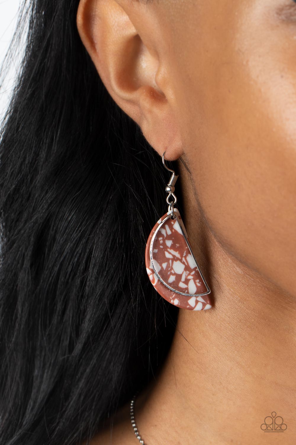 A faux Adobe stone semicircle disc, flecked with white accents, is outlined with a dainty silver half moon frame swaying in front for a flashy fad-inspired fashion
