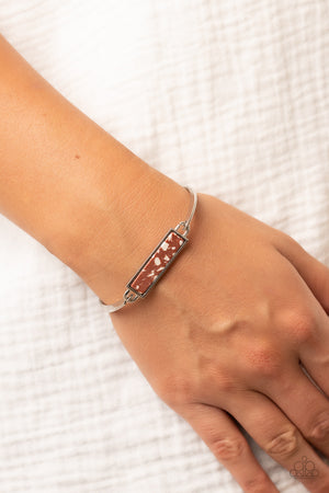 sleek silver frame, a brown terrazzo-like stone frame is fitted in place across the center of a dainty silver bangle