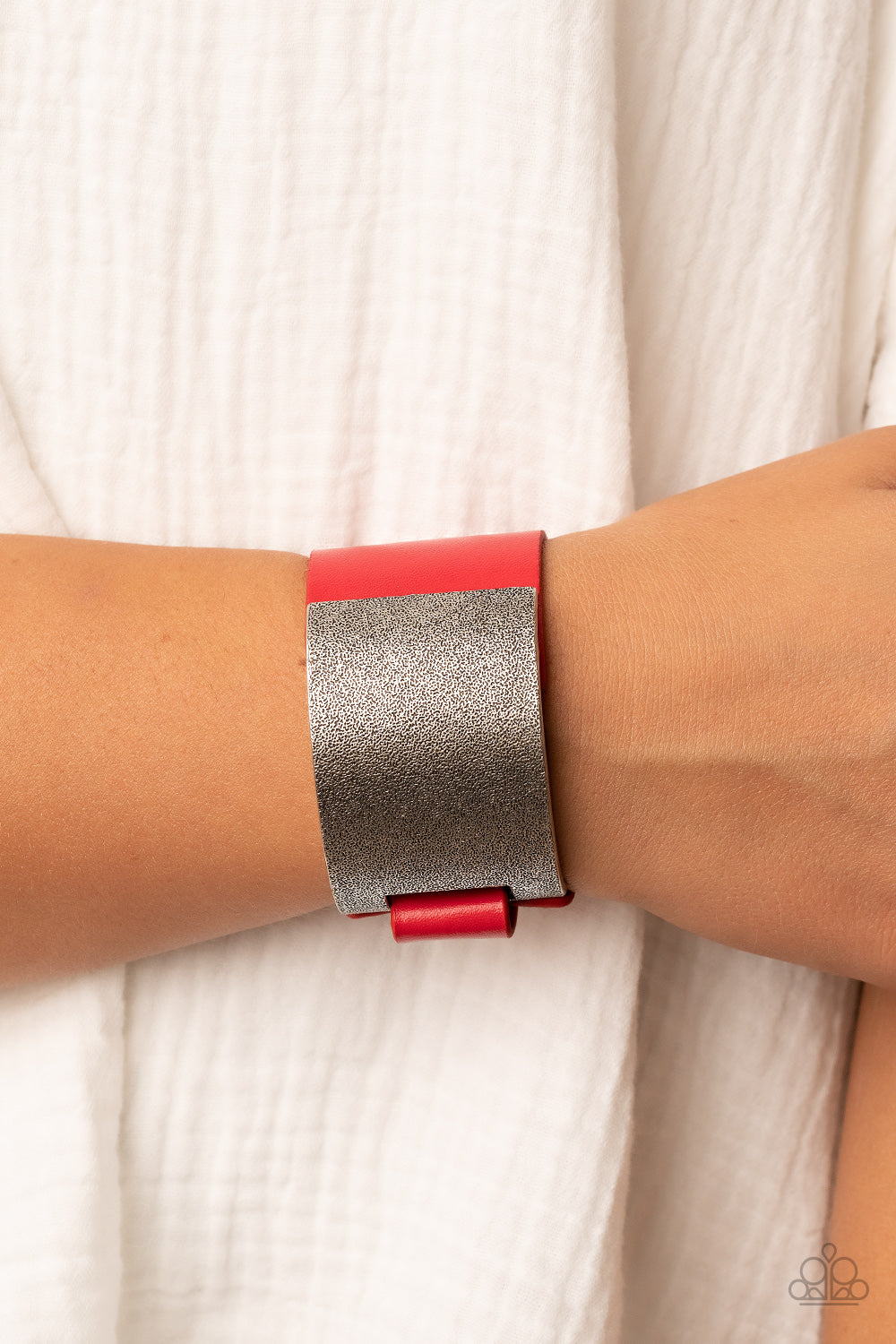 curved tin finished silver panel, coated in antiqued texture, attaches to a wide red leather band with silver snaps