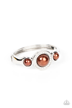 glitzy ring of glassy white rhinestones, an oversized brown pearl 