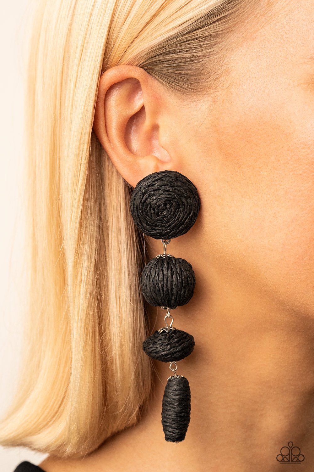 Strands of black crepe-like twine wraps around circle, sphere, oval, and oblong frames that delicately connect into a decorative tassel