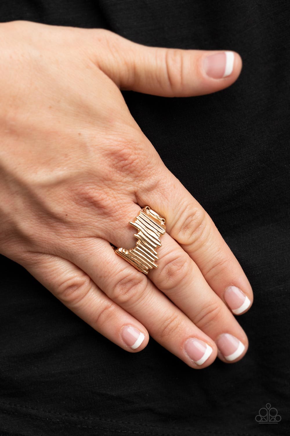 Wavy gold bars asymmetrically stack into an uneven band across the finger