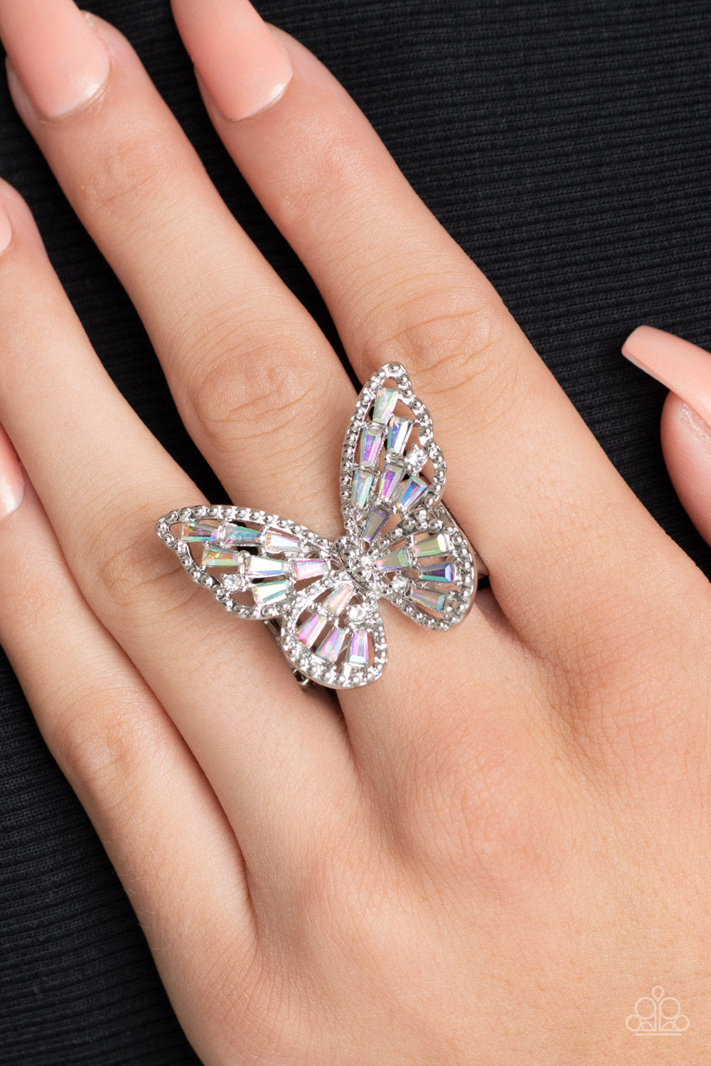 merald cut iridescent rhinestones are sprinkled across the studded wings of a shiny silver butterfly