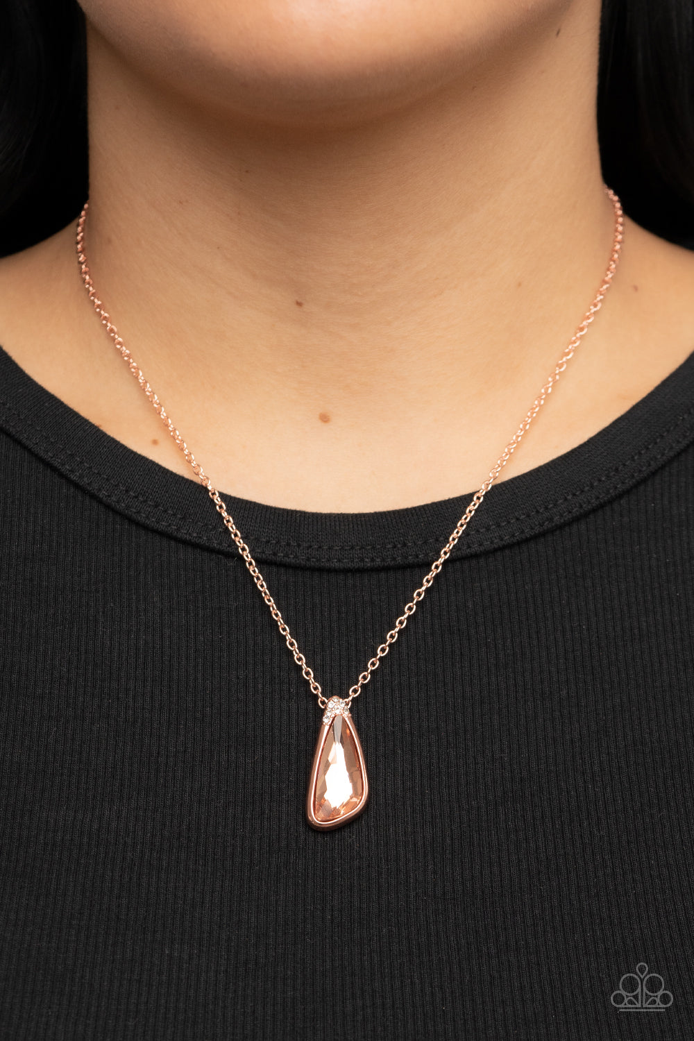 asymmetrical coppery gem is pressed into a shiny copper frame dusted in glassy white rhinestones