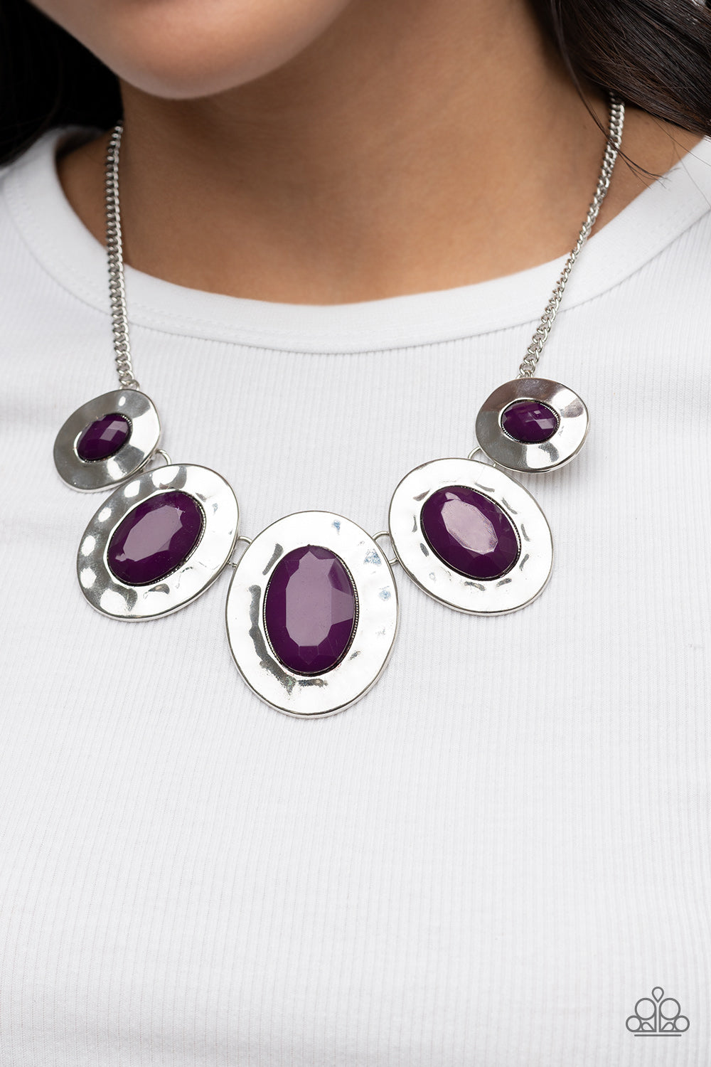 Gradually increasing in size, hammered silver oval frames are dotted with faceted plum beads as they delicately link below the collar