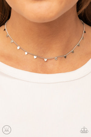 Dainty silver hearts dance from a dainty silver chain around the neck, creating a flirtatious fringe