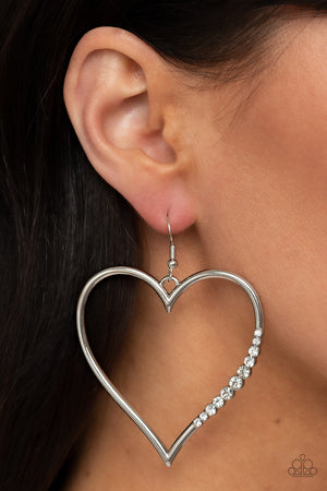 glassy white rhinestones adorns a curvaceous silver heart frame, resulting in a heart-stopping sparkle