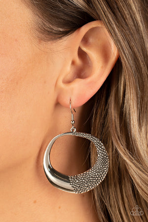 asymmetrical silver hoop is embossed in rugged pebble like texture