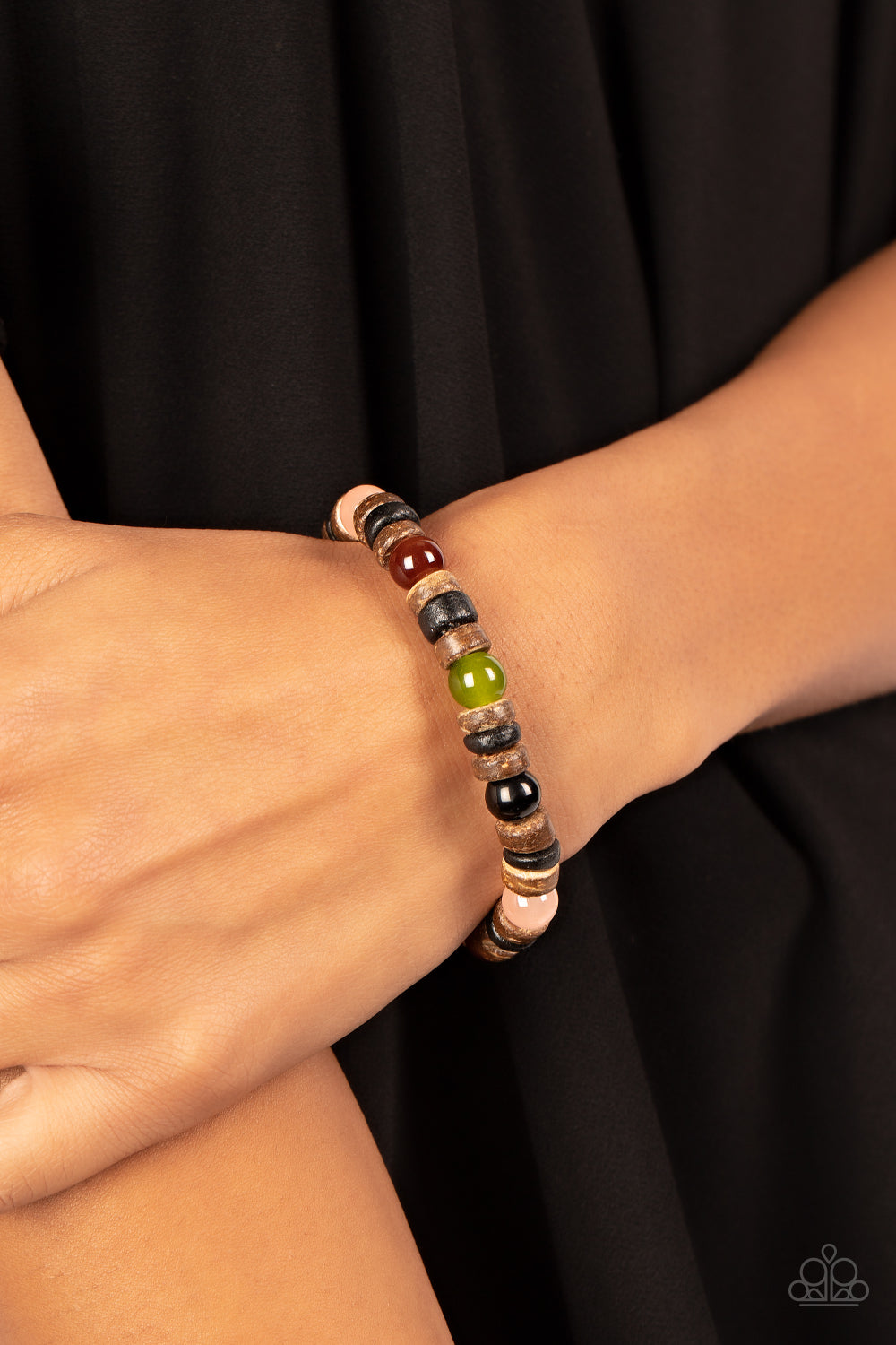 Glassy multicolored stone beads join trios of black and brown wooden discs along stretchy bands around the wrist