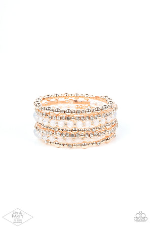 rose gold beads, rose gold cubes, opaque crystals, and glassy white rhinestones are threaded along a coiled wire
