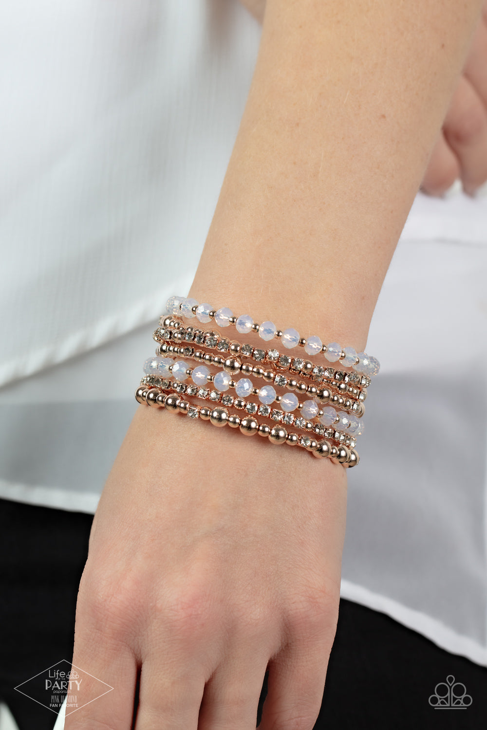 rose gold beads, rose gold cubes, opaque crystals, and glassy white rhinestones are threaded along a coiled wire